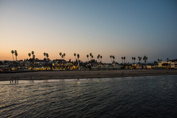 Fototapeta na wymiar Palm trees and beach view on sunset from the pier, Santa Cruz, California, USA