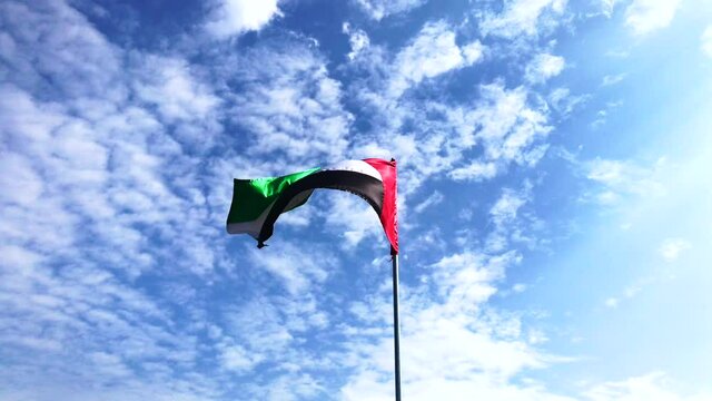 UAE flag waving in the sunset sky. UAE flag day.