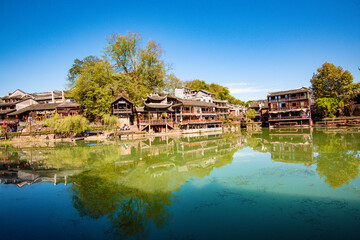 the river, the boat, stone bridge and the old houses at ancient phoenix town in the morning at...
