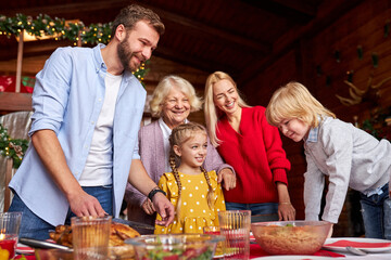 family laugh, enjoy time in pre-holiday mood, stand behind decorated table