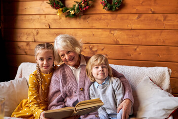 elderly woman read fairy tales for children, spend more time together, on the eve of new year,...