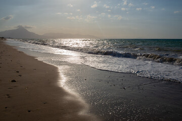 Beach at sunset in Sicily, Italy. Landscape with Mediterranean sea and mountains