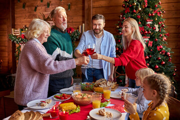 happy family clinking glasses with wine, celebrating christmas or new year, congratulating, say toast