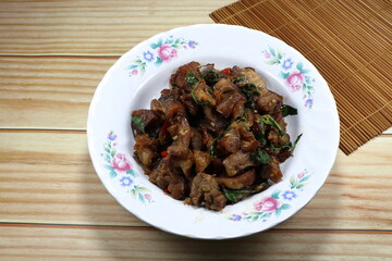 Fried and stirred spicy crispy pork with chilly and basil on the plate. Famous traditional appetizer menu in Asia restaurant. 