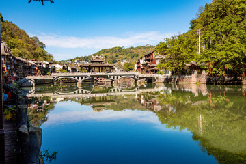 the river, the boat, stone bridge and the old houses at ancient phoenix town in the morning at Hunan, China.