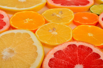 Fototapeta na wymiar Sliced citrus fruits background. Red grapefruit, oranges, lemons, lime, mandarins