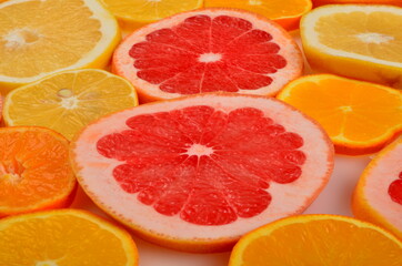 Naklejka na ściany i meble Sliced citrus fruits background. Red grapefruit, oranges, lemons, lime, mandarins