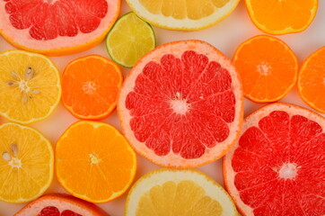 Sliced citrus fruits background. Red grapefruit, oranges, lemons, lime, mandarins