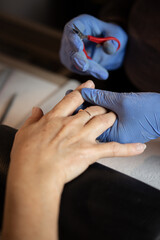 Closeup shot of a woman in a nail salon receiving a manicure by a butician