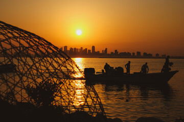 silhouette of the fishing boat and fisher man in Nurana island Bahrain