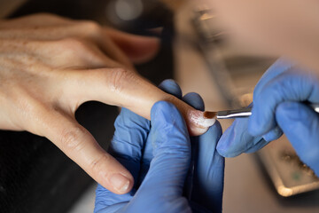 Fototapeta na wymiar Closeup shot of a woman in a nail salon receiving a manicure by a butician