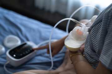 Mom use electric breast pump feeding for her baby.