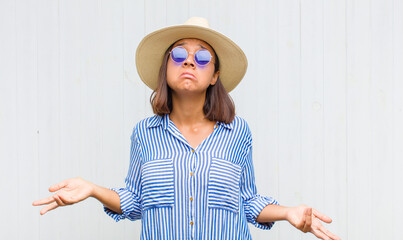 latin woman feeling puzzled and confused, unsure about the correct answer or decision, trying to...