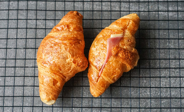 Top view of Croissants on a cooling rack on textured grey background