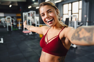 Excited athletic sportswoman showing copyspace while taking selfie