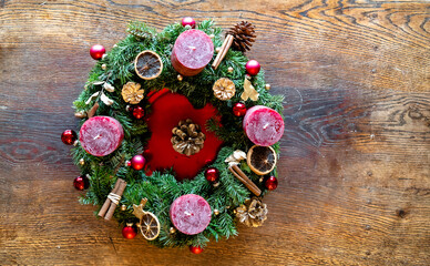 Adventskalender selbst gemacht. Rote Kerzen, Zimt, Kugeln, getrocknete Orangen, Tannenzapfen. Gold