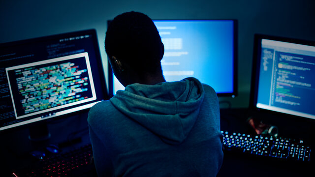 Hacker working on computer monitors