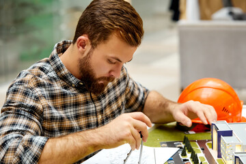 young student architect working on architectural project concept, using 3d model layout, university student is planning engineering design, brainstorming at workplace alone