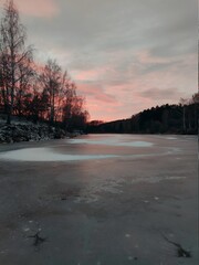 frozen surface of the lake against the background of sunset in a beautiful evening landscape