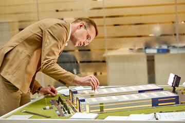 caucasian architect working on house model scale, planning building project. in an architectural firm office working alone