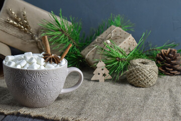 Large coffee mug with marshmallows and spices on the background of objects for gift wrapping