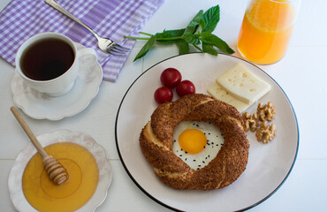 Delicious breakfast plate consisting of bagels, eggs, cheese, walnuts and tomatoes.