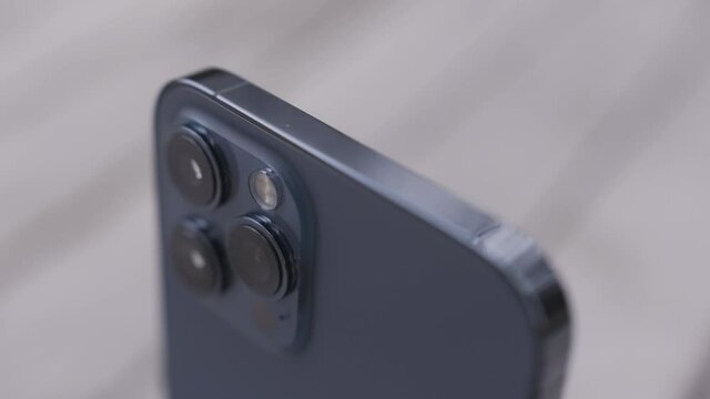 Close up details of a beautiful dark blue smartphone with three cameras. Action. Concept of modern technologies and design, device isolated on white background.
