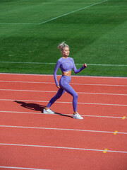 Fototapeta premium sexy fitness woman in sportswear. athletic lady warming up on stadium running track. female athlete do sport workout. trainer or coach training. perfect body shape. healthy and sporty