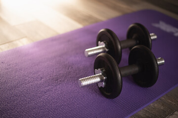 Obraz na płótnie Canvas Dumbbells on purple mat in living room. Workout at home