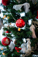 Christmas background. Detail view of red and silver baubles and festive decorations hanging on a green christmas tree.