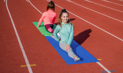 gymnasts prepare for competition. athletes warm up on stadium gym. split flexibility. children training at school physical lesson. teenage girls stretching before training. Everything is possible