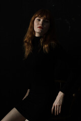 Portrait of ginger woman with red lips in black dress 