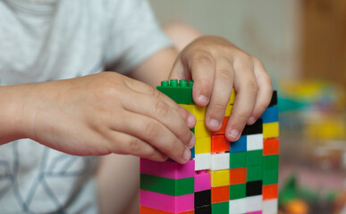 Small hands of the child collects the bright plastic colored Designer. Educational toys and Early learning