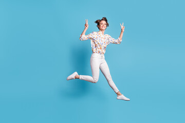 Fototapeta na wymiar Full length photo of young girl happy positive smile jump show cool peace v-sign isolated over blue color background