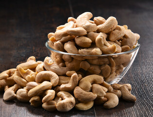 Bowl with cashew nuts on wooden table