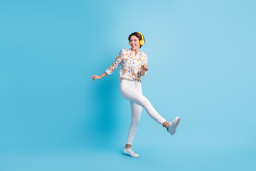 Fototapeta na wymiar Full body photo of young girl happy smile excited have fun enjoy listen music earphones dance isolated over blue color background