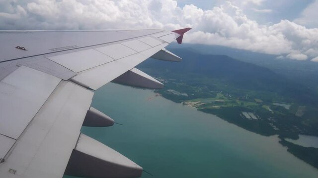 Travel Video View from the airplane window over the wings and engines The aircraft are take off or flying through island and Good weather transportation concept 4K Resolution wide angle shot.