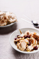 Not traditional Eton mess. Meringue, pistachio, cherry and caramel sauce dessert. Selective focus