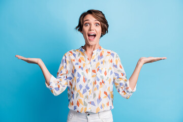 Photo of amazed happy crazy pretty girl hold two hands empty space unbelievable sale isolated on blue color background