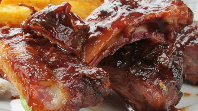 Slider shot of gourmet barbecue ribs with french fries close up