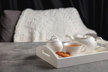 English tea and cakes on wooden grey table, closeup. White wooden tray with tea set. The concept of home atmosphere and comfort, romantic date, winter, home comfort, indoors, Christmas or New Year.