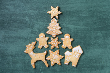 Top view of Christmas tree and snowflake cooikes with gingerbread man wearing mask.