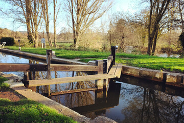 Fototapeta na wymiar Unstead Lock gates on the River Wey on a cold sunny winter's morning, Godalming, Surrey, UK