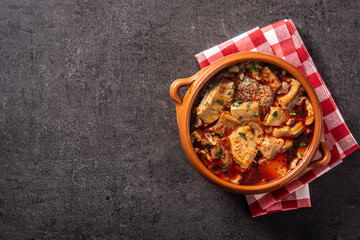 Traditional mondongo or el menudo soup in bowl on black background. Top view. Copy space