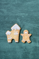 Top view of Christmas tree and snowflake cooikes with gingerbread man wearing mask.