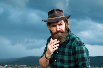 bad habit. texas brutal cowboy. brutal hipster with moustache in hat. fashion model wear casual west clothes. male beauty standard. looking so trendy. Confident and handsome man. bearded man