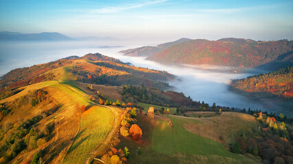 Beautiful Autumn mountain panorama. Morning thick fog cover valley aerial view. Fantastic fall sunrise