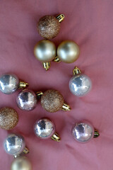 Christmas baubles in pink and gold tones. Flat lay, pink background.