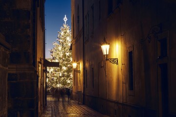 Narrow street Old Town against illuminated Christmas tree