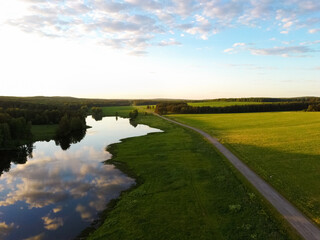 Fototapeta na wymiar road near the river and forest on a summer day at sunset.view from a drone.